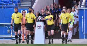 Referees and players walk onto the field for a Dallas Cup match.