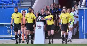 Referees and players walk onto the field for a Dallas Cup match.