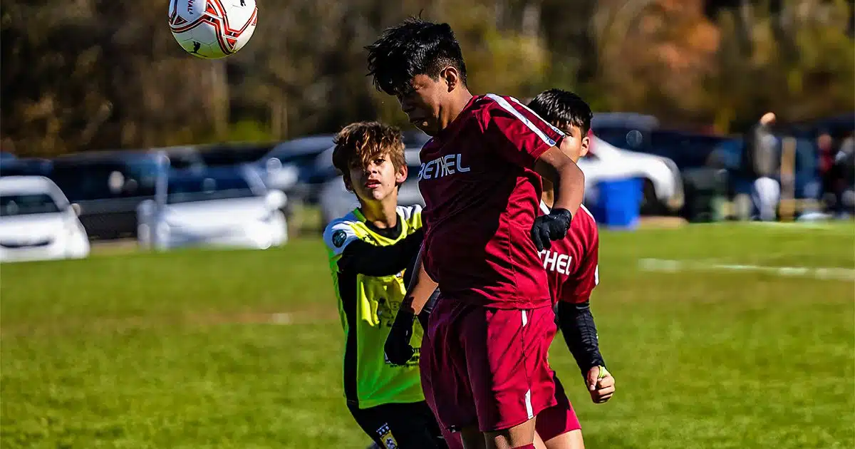 A youth player goes up for a header at the Connecticut Cup.